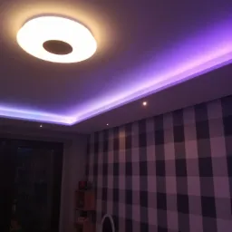 Pokój z podświetlanym sufitem w kolorze fioletowym i okrągłą lampą sufitową, ściana w kratę.