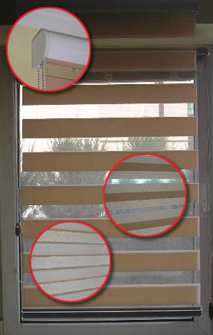 Zasłonięte okno z roletami dzień-noc w beżowo-białej kolorystyce, widoczne detale mechanizmu i konstrukcji, z zewnątrz widok na zieleń.