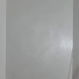 Świeżo pomalowana ściana w odcieniu chłodnej szarości, widoczne delikatne smugi po wałku, gładka powierzchnia z subtelnym połyskiem.