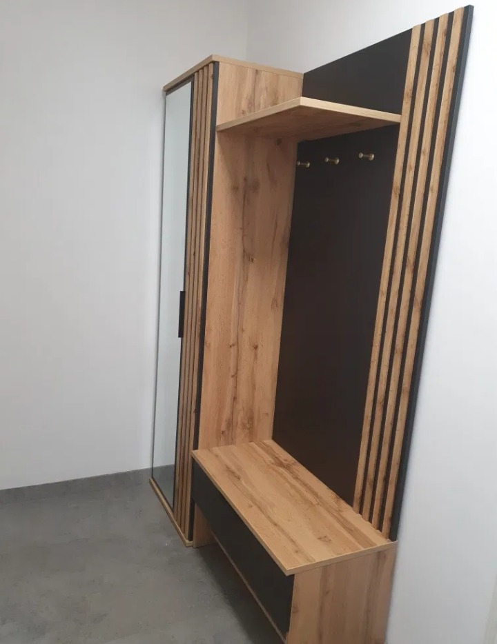 Komplet mebli do przedpokoju z lustrem, siedziskiem i panelem z wieszakami, wykończony w okleinie imitującej drewno i czarnym macie.