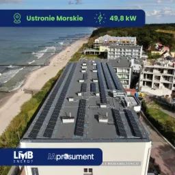 Instalacja paneli słonecznych na dachu budynku w Ustroniu Morskim, widok z g&oacute;ry na morze i plażę, moc instalacji 49,8 kW.