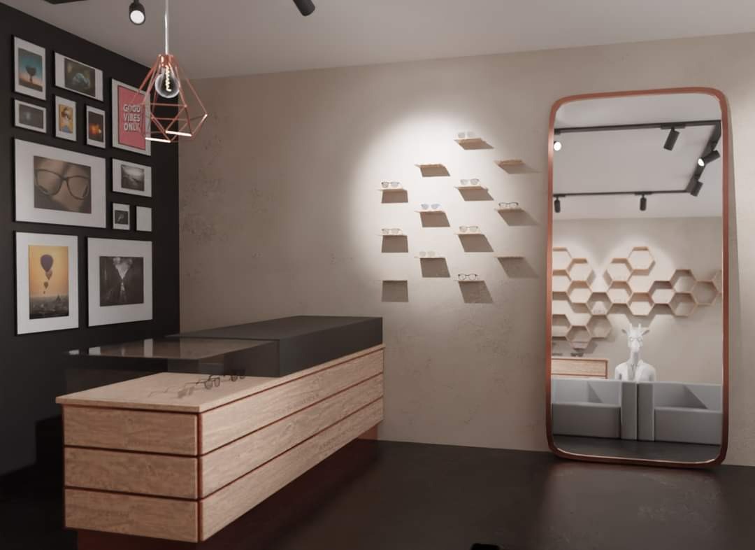 Wnętrze salonu optycznego z drewnianą ladą, ekspozycją okularów na ścianie i dużym lustrem w miedzianej ramie odbijającym manekina z głową żyrafy.