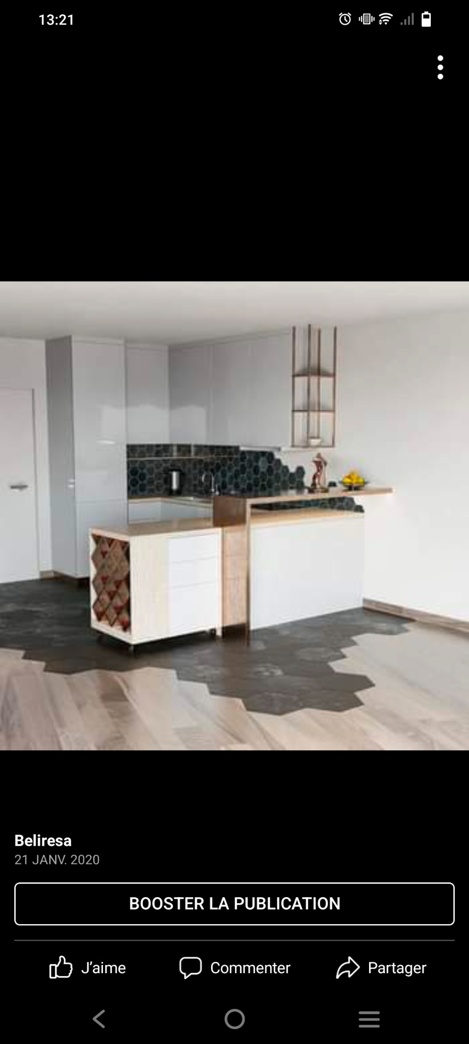 Nowoczesna kuchnia z białymi szafkami, heksagonalnymi płytkami nad blatem i drewnianym regałem na wino wbudowanym w wyspę, uzupełniona drewnianą podłogą z heksagonalnymi ciemnymi wstawkami.