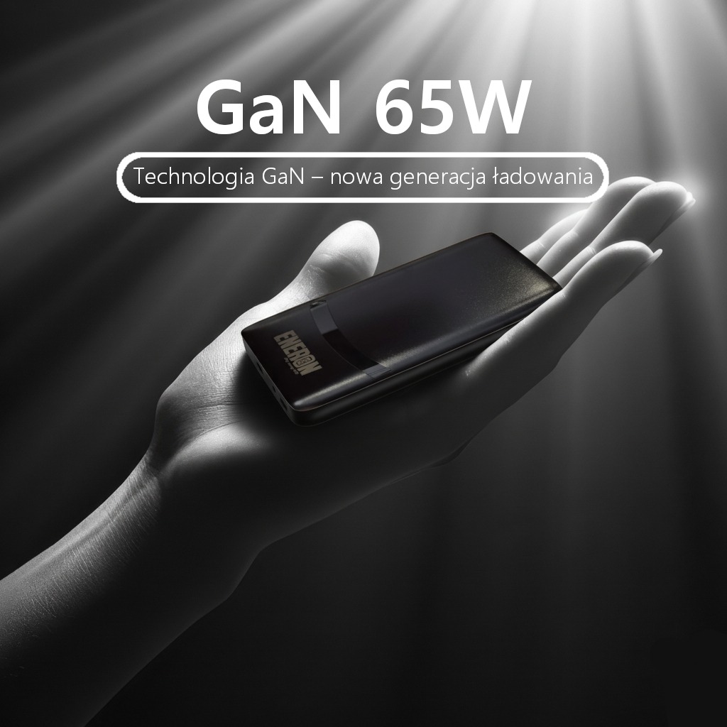 Czarno-białe zdjęcie dłoni trzymającej czarny powerbank GaN 65W z napisem Energen, oświetlony promieniami światła. Technologia GaN - nowa generacja ładowania.