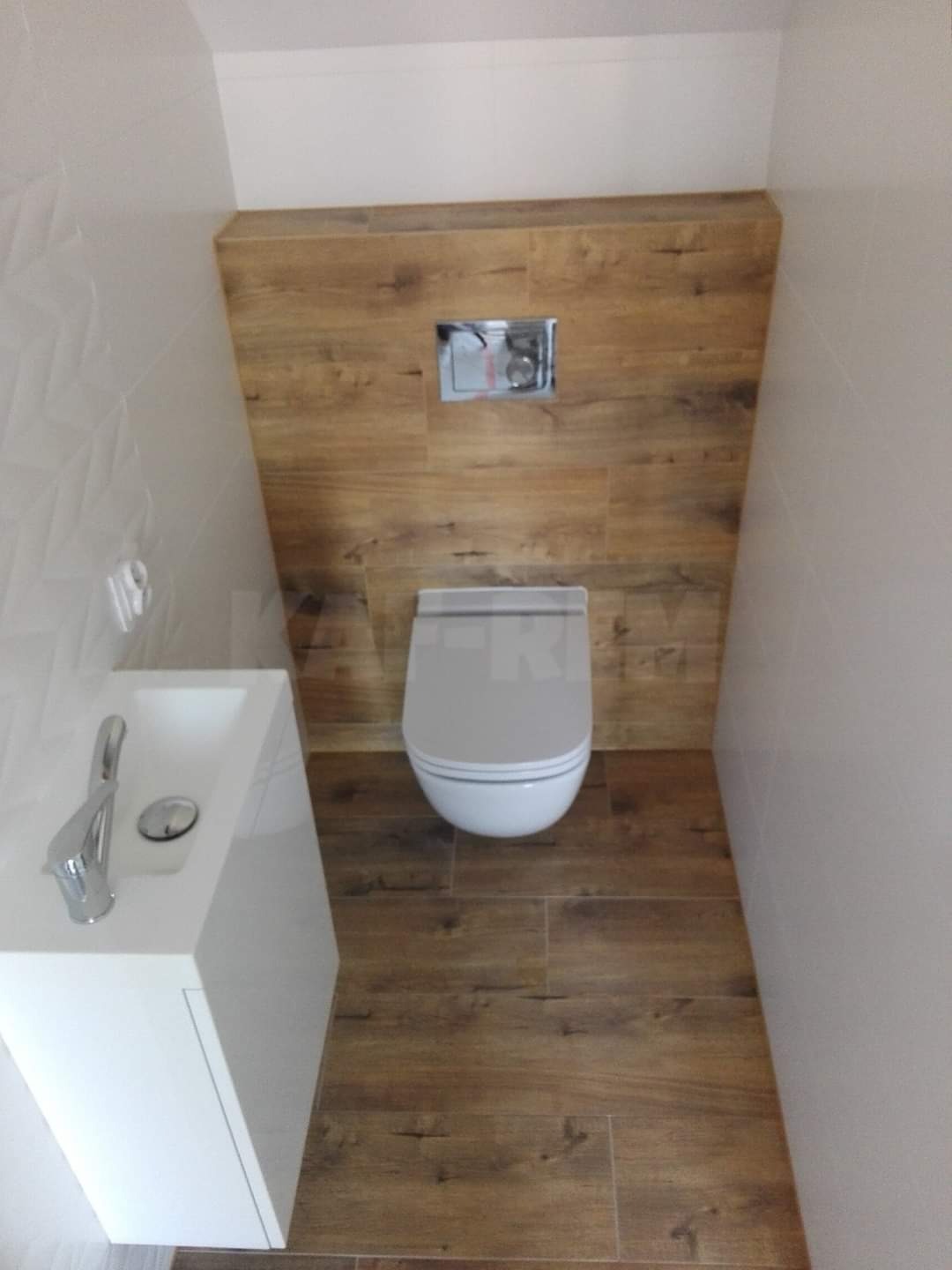 Nowoczesna toaleta w Zabrzu z podwieszaną muszlą klozetową i umywalką, wykończona płytkami imitującymi drewno na podłodze i ścianie za muszlą, oraz białymi płytkami 3D na ścianie z lewej strony.