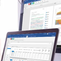 Ekrany laptopa i monitora wyświetlające dokumenty tekstowe i wykresy, prawdopodobnie raporty lub analizy danych.
