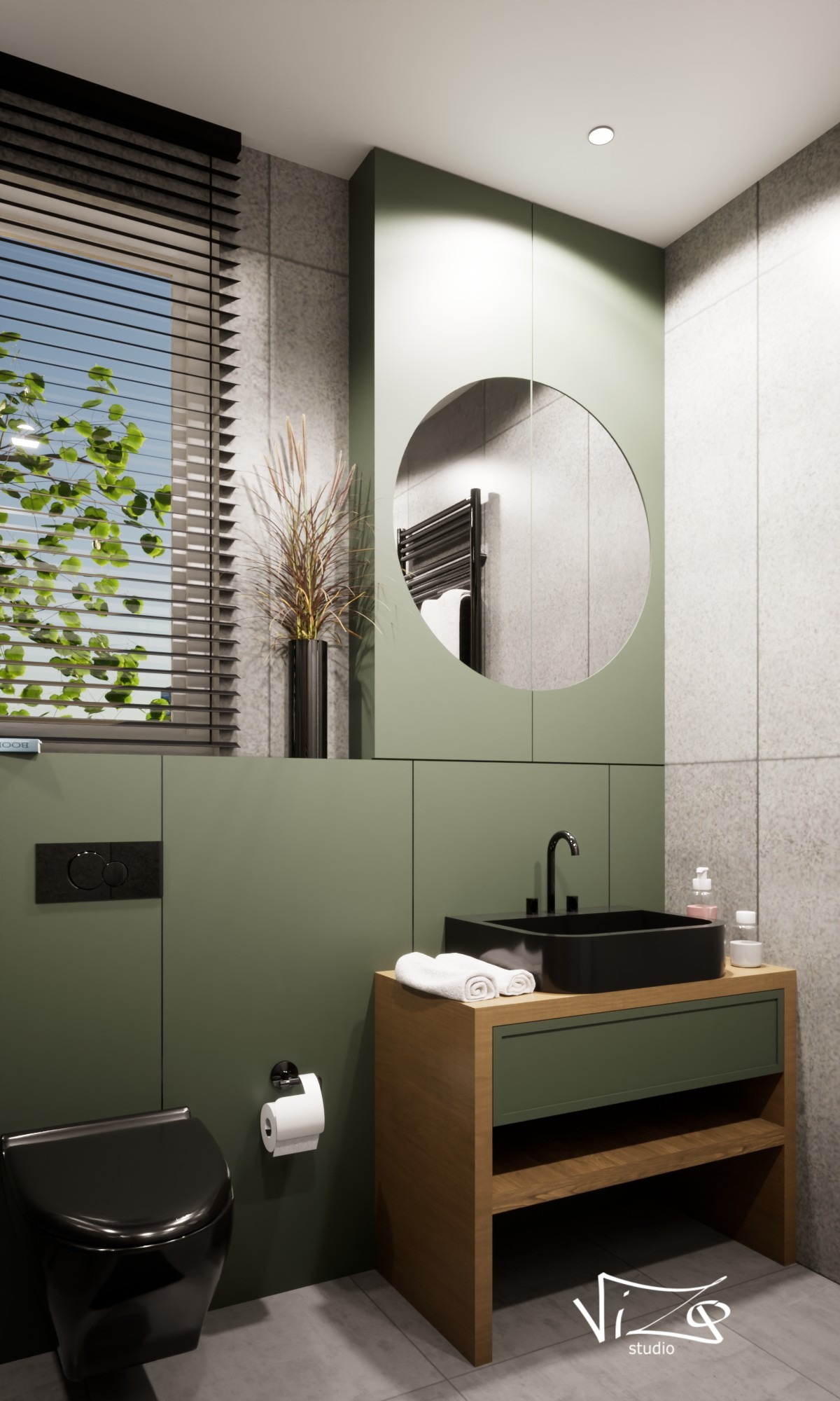 Nowoczesna łazienka w odcieniach zieleni i szarości z czarną armaturą i umywalką, okrągłe lustro z odbiciem grzejnika, minimalistyczny design.