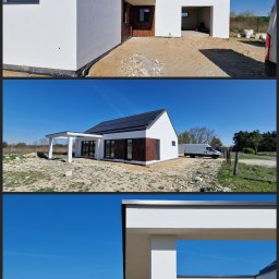 TaFFa-Dawid Wnętrzak - Nowoczesny dom jednorodzinny z białymi ścianami i drewnianymi elementami wykończeniowymi, częściowo z panelami słonecznymi na dachu, otoczony terenem w trakcie zagospodarowywania, widoczny biały...