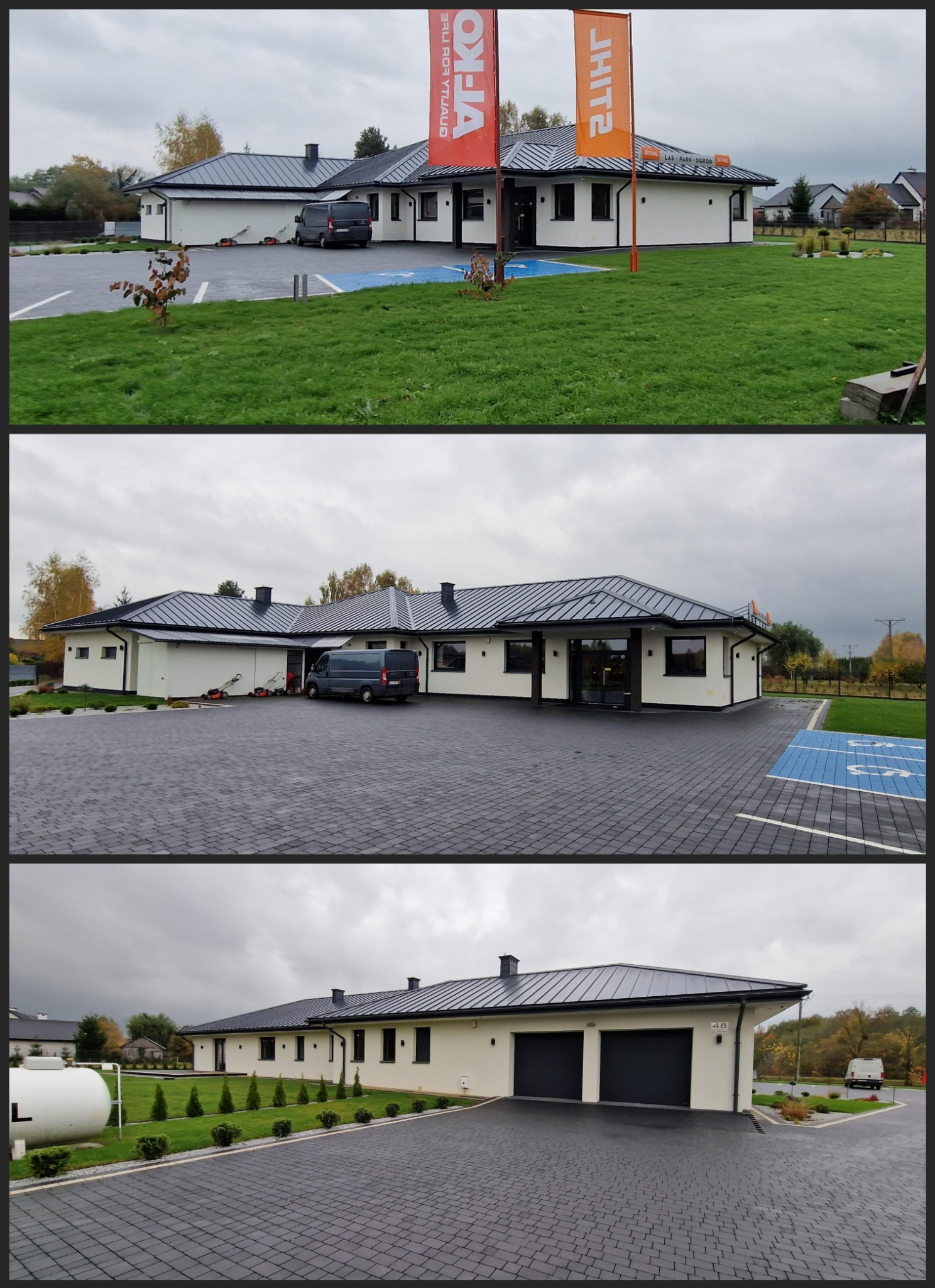 Nowoczesny parterowy budynek z białymi ścianami i ciemnym dachem, otoczony brukowanym podjazdem i trawnikiem, z widocznymi flagami reklamowymi i zaparkowanym vanem.