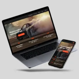 Laptop i smartfon prezentujące responsywną stronę internetową wypożyczalni sportowych aut z dynamicznym tłem samochodu w poślizgu, widoczne statystyki: 18 samochodów w kolekcji, 700 KM...