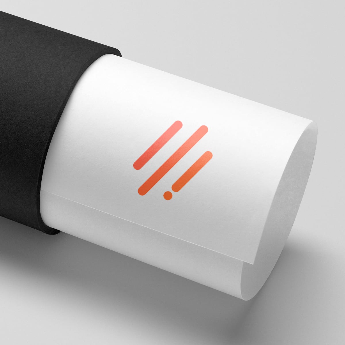 Zrolowany plakat z minimalistycznym, pomarańczowym logo w czarnej tubie na jasnoszarym tle.