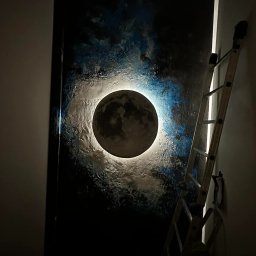 Marta Karpisz - tynkowanie dekoracyjne - Niedokończona malarska dekoracja ścienna z motywem księżyca otoczonego błękitną mgławicą, widoczna drabina oparta o ścianę, słabe oświetlenie.