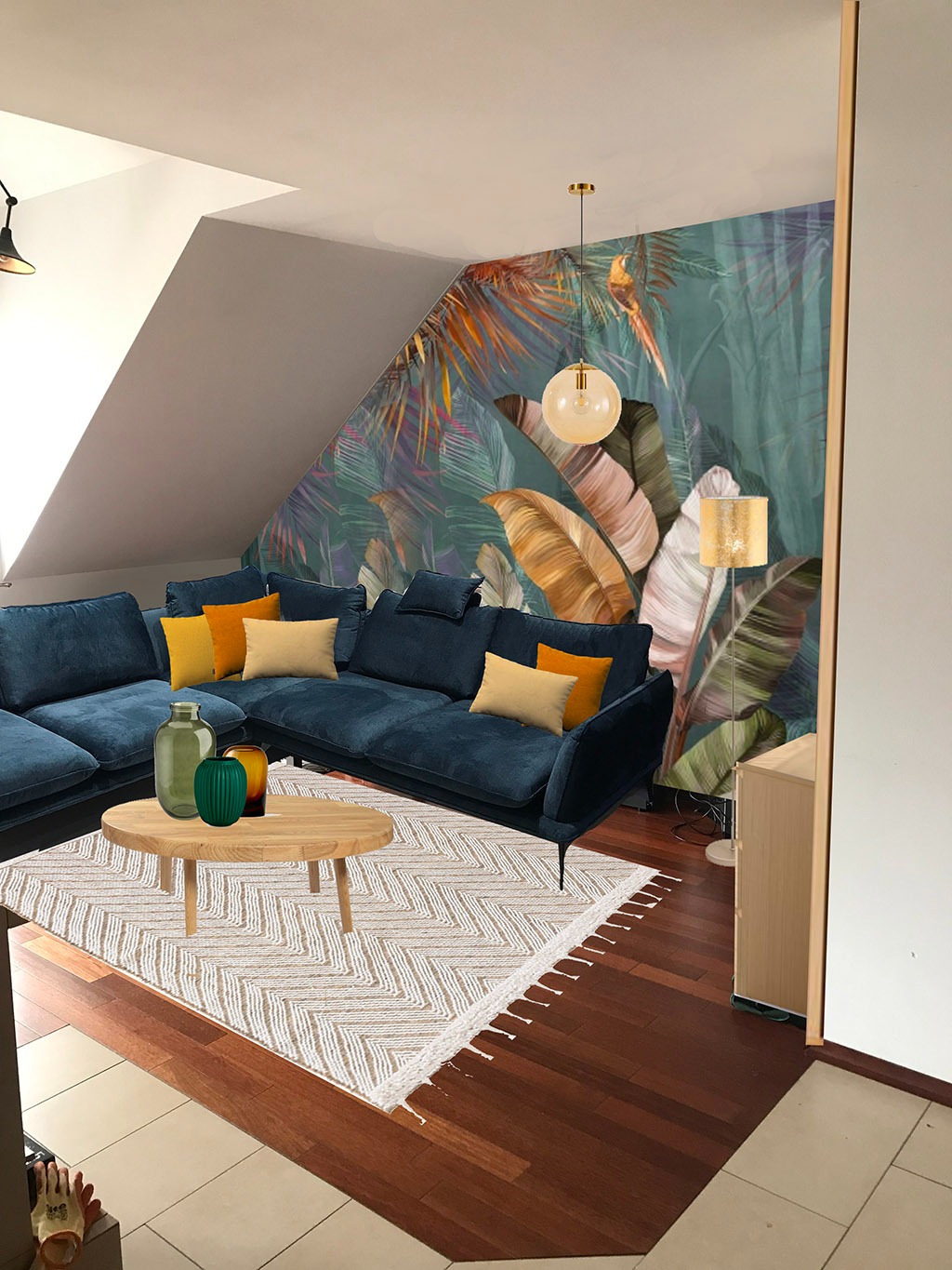 Wizualizacja salonu z narożną sofą w odcieniach granatu, drewnianym stolikiem kawowym z zielonymi wazonami i dywanem w zygzaki na drewnianej podłodze, tłem jest ściana z motywem tropikalnych liści...