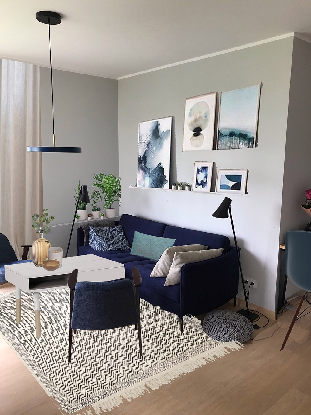 Salon w odcieniach szarości i granatu: granatowa sofa z poduszkami, biały stolik kawowy z dekoracjami, krzesło z ciemnego drewna, dywan w zygzaki, minimalistyczna lampa wisząca i grafiki na ścianie.