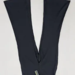 Para czarnych, rozszerzanych spodni ułożonych w kształt litery V na białym tle, z widoczną metką.