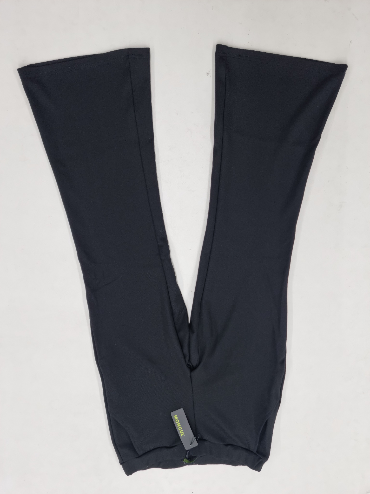 Para czarnych, rozszerzanych spodni ułożonych w kształt litery V na białym tle, z widoczną metką.