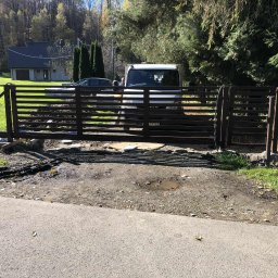 Stalmar - Nowoczesna brama wjazdowa z poziomych profili, częściowo zamontowana. Widoczny samochód dostawczy w tle i elementy montażowe. Ujęcie z poziomu ulicy.