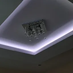 Sufit podwieszany z oświetleniem LED w kształcie prostokąta i nowoczesnym żyrandolem z kryształkami.