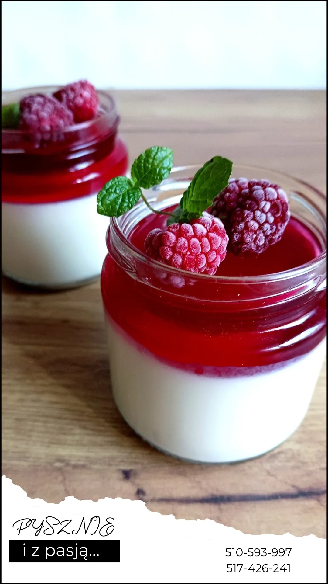 Deser w słoiku: biała warstwa, czerwona galaretka, maliny i listki mięty na wierzchu, drugi słoik w tle, drewniana powierzchnia.