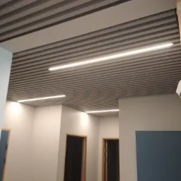 Sufit z listwami akustycznymi w szarym kolorze i wbudowanym oświetleniem LED, widok na korytarz z drzwiami.