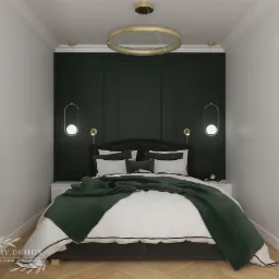 Sypialnia w stylu minimalistycznym z ciemnozieloną ścianą, okrągłym złotym żyrandolem i łóżkiem z narzutą w tym samym odcieniu zieleni.