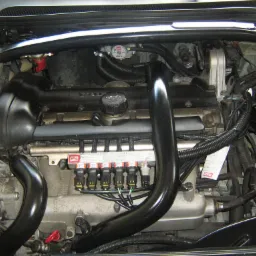 Widok z bliska na silnik samochodu z zainstalowaną instalacją LPG, widoczne wtryskiwacze gazu BRC, przewody i reduktor.