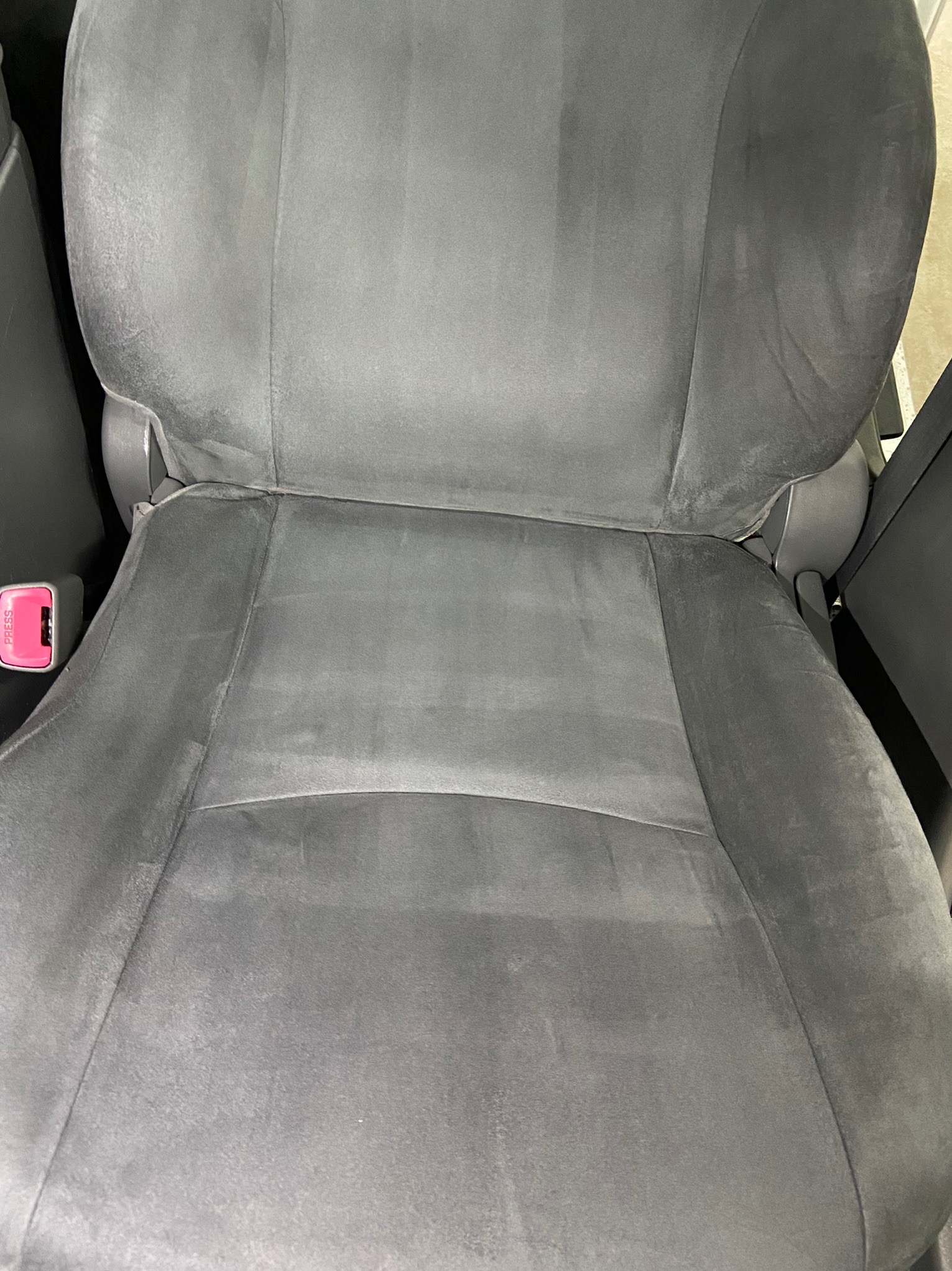 Szare welurowe siedzenie samochodowe po czyszczeniu, widoczne różnice w odcieniach na powierzchni siedziska.