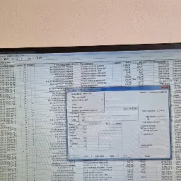 Ekran laptopa z otwartym programem księgowym prezentującym listę faktur, z widocznymi kolumnami takimi jak data wystawienia, numer dokumentu, opis zdarzenia, kwoty netto i VAT, oraz nazwa kontrahenta.
