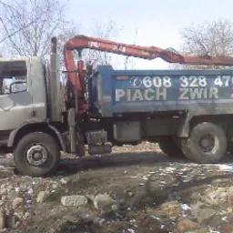 Ciężarówka wywrotka z dźwigiem HDS na placu budowy, widoczne gruz i ziemia.