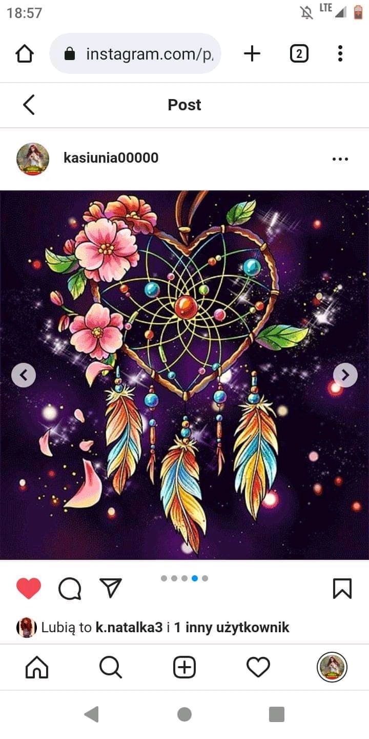 Ilustracja cyfrowa przedstawiająca ręcznie wykonany łapacz snów w kształcie serca, ozdobiony kwiatami, piórami i koralikami na fioletowym tle z efektem kosmicznego pyłu.