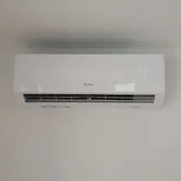 Biały klimatyzator marki Gree zamontowany na jasnej ścianie, wyświetlający temperaturę 19 stopni.