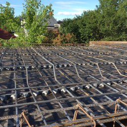 B&B Gw Sp Zoo - Zbrojenie płyty fundamentowej z dystansami z tworzywa sztucznego, widok z góry na tle zieleni i zabudowy jednorodzinnej.