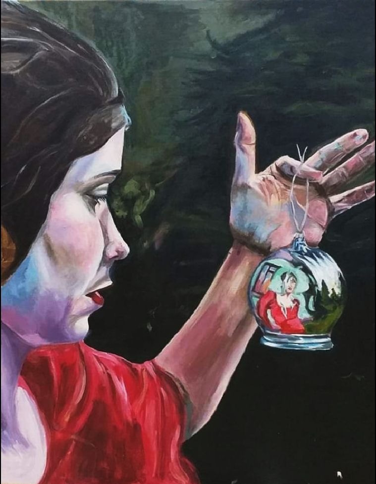 Obraz olejny przedstawiający kobietę z ciemnymi włosami, trzymającą w dłoni bombkę choinkową, w której odbija się postać innej kobiety w czerwonej sukience na tle zieleni.