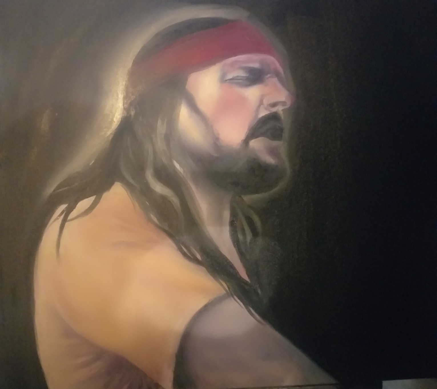 Portret olejny mężczyzny z długimi włosami i czerwoną opaską na głowie, namalowany w ciemnych tonacjach z delikatnym oświetleniem wokół głowy.