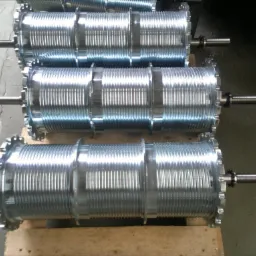 Trzy identyczne, nowe, metalowe bębny z nawiniętymi linkami, leżące na drewnianej palecie. Widoczne osie z zębatkami.