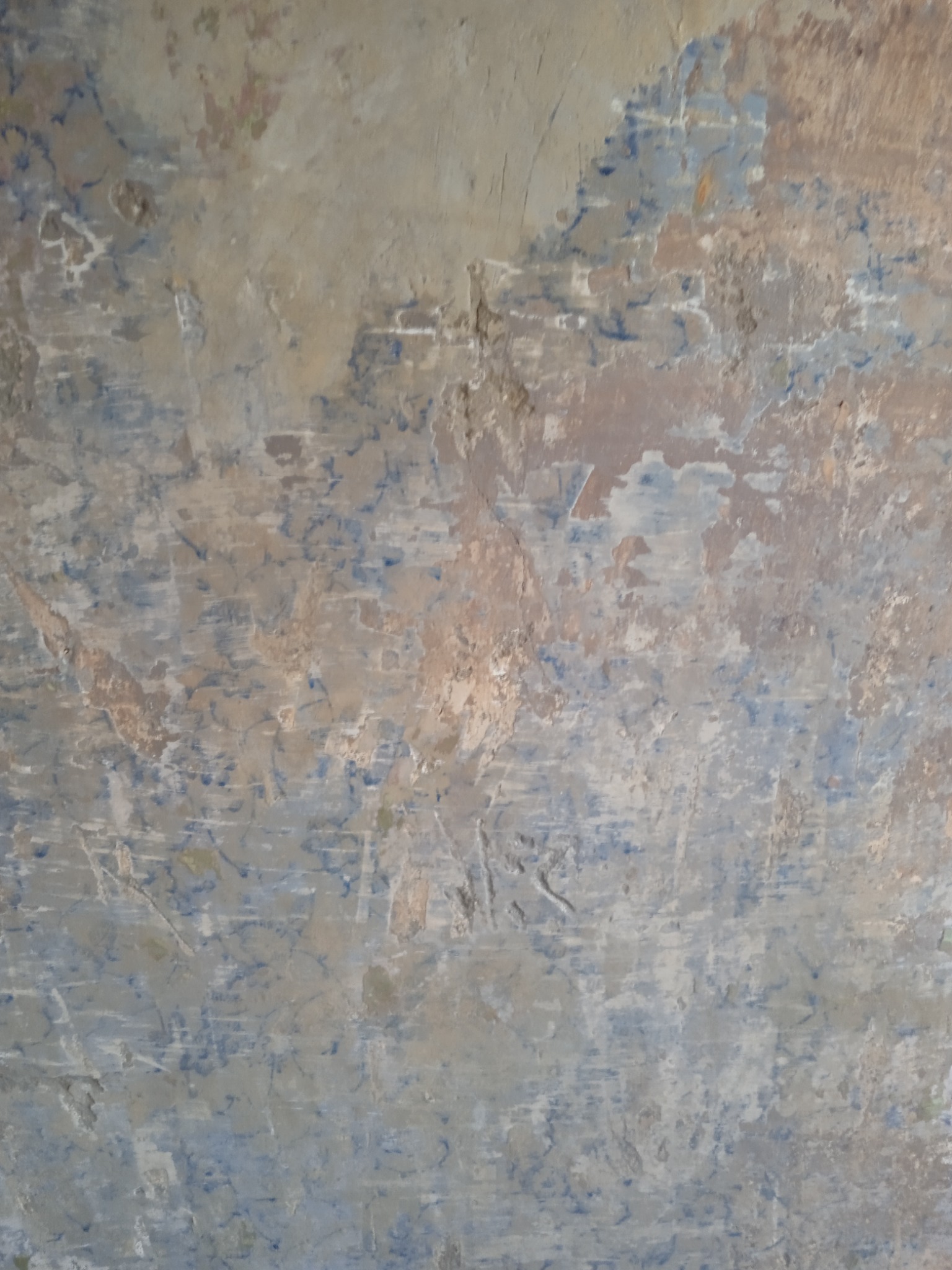 Niedokończona ściana po szpachlowaniu z widocznymi śladami po szpachli, fragmentami starej farby i nierównościami powierzchni.