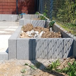 Scann Piotr Froń - Budowa obrzeża z betonowych bloczków przy ogrodzeniu z siatki w Rzeszowie. Wypełnienie ziemią i gruzem.