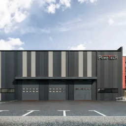 Wizualizacja nowoczesnego budynku przemysłowego z szarymi panelami pionowymi, trzema bramami garażowymi, częścią biurową w kolorze koralowym, logo firmy PompTech, samochodem osobowym na parkingu...