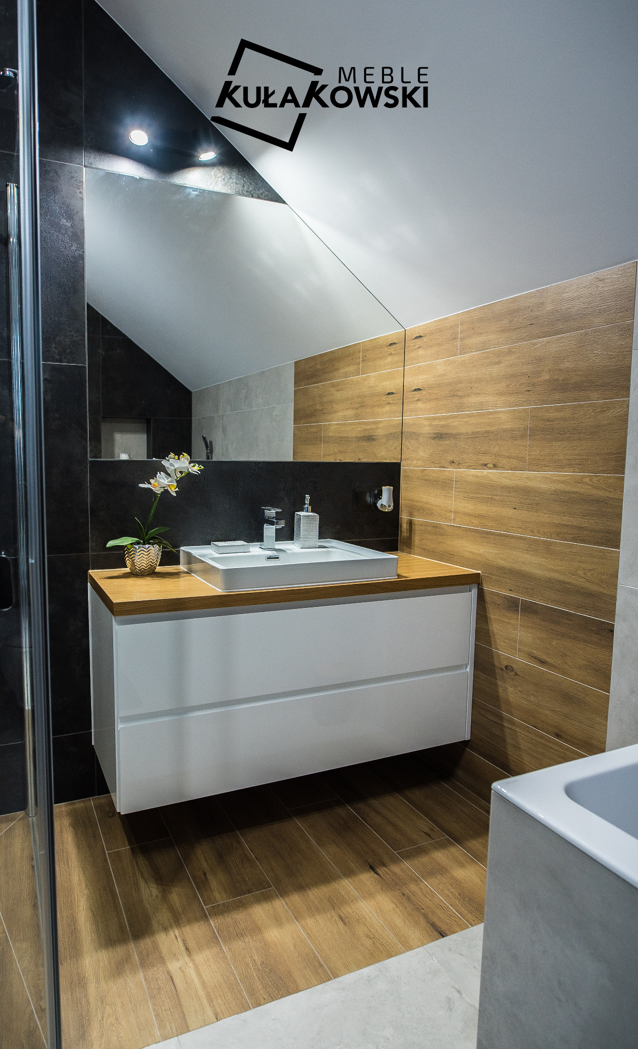 Nowoczesna łazienka w Białymstoku z białą szafką pod umywalkę z drewnianym blatem, drewnopodobnymi płytkami na ścianie i podłodze oraz lustrem na ścianie.