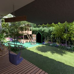 MB- Projektowanie ogrodów - Zadaszony taras z drewnianą podłogą i wiklinowym fotelem bujanym, widok na plac zabaw dla dzieci z huśtawką, domkiem na drzewie i tablicą, otoczony bujną zielenią i kwiatami.