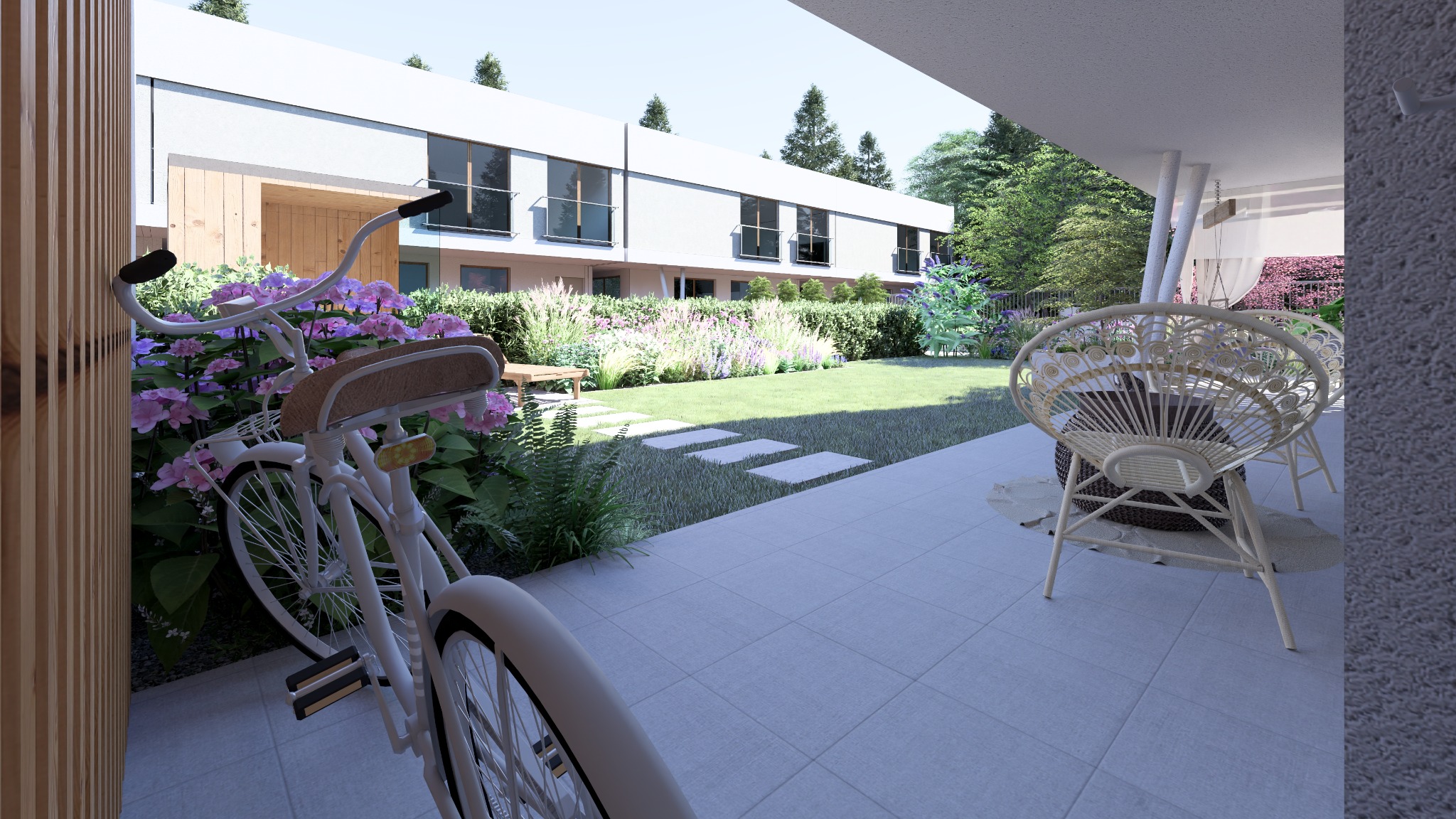Nowoczesny dom z ogrodem, widok z zadaszonego tarasu z rattanowymi krzesłami, rower oparty o ścianę z kwitnącymi hortensjami, trawnik z kamiennymi płytami.