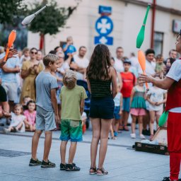 Cyrkowy pokaz uliczny podczas festiwalu w Rzeszowie. Na zdjęciu żonglerka maczugami we dwoje między osobami z publiczności 