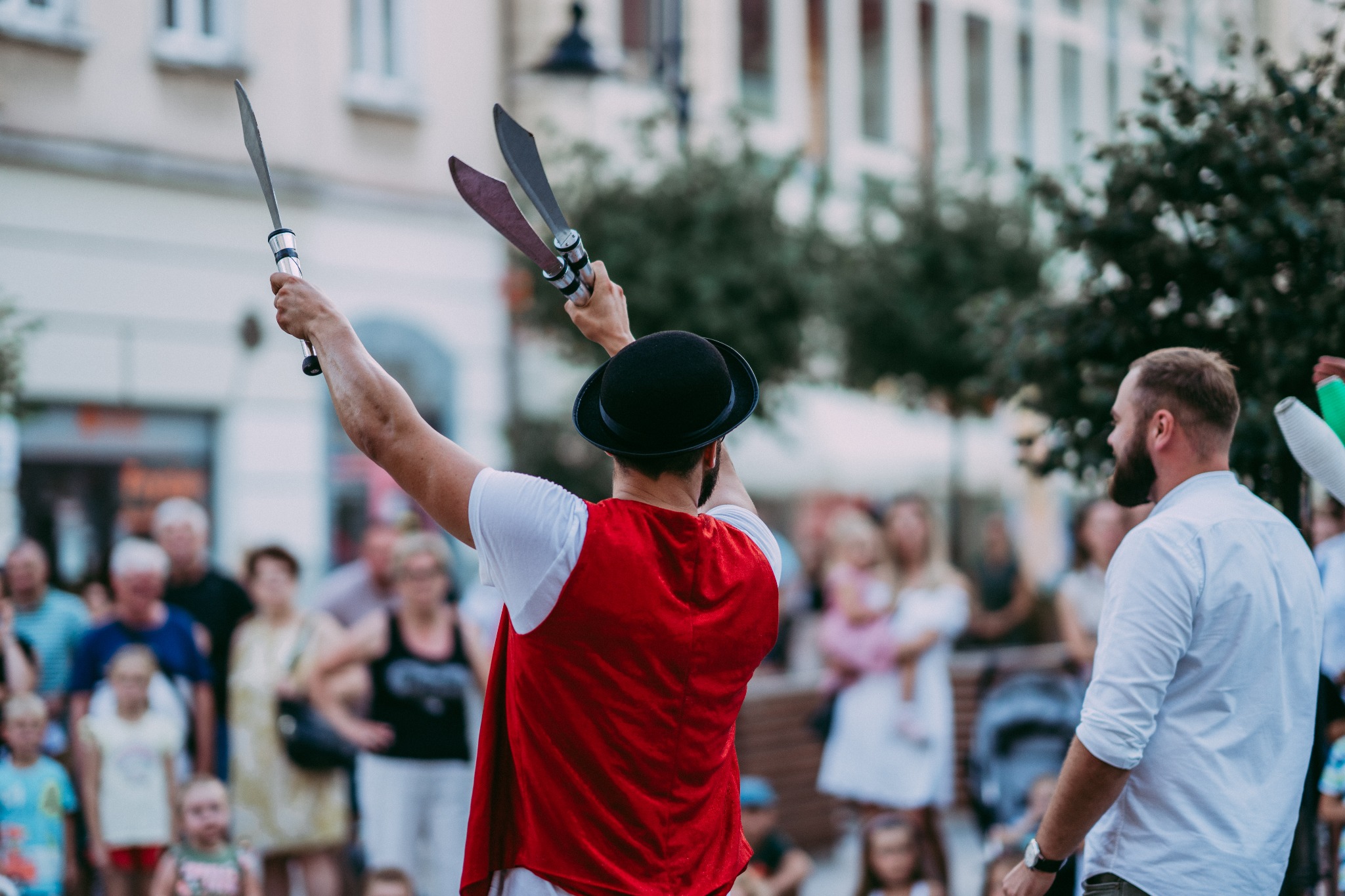 Cyrkowy pokaz uliczny podczas festiwalu w Rzeszowie. Na zdjęciu żonglerka mieczami we dwoje między osobą z publiczności