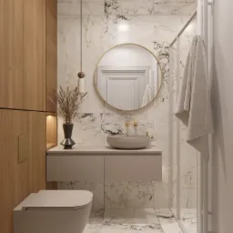 Elegancka łazienka w odcieniach beżu i bieli z marmurowymi płytkami, okrągłym lustrem w złotej ramie, wiszącą umywalką i drewnianą zabudową, akcentowana designerską lampą wiszącą i dekoracyjnym...