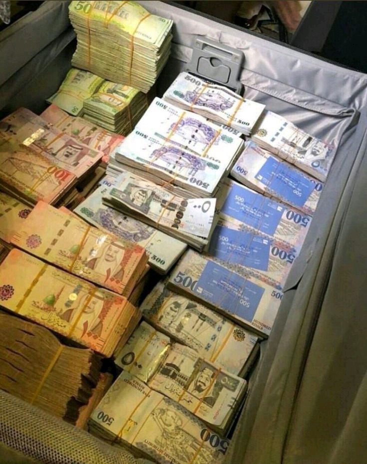 Otwarty szary kufer wypełniony plikami banknotów różnej wartości, zabezpieczonych gumkami.