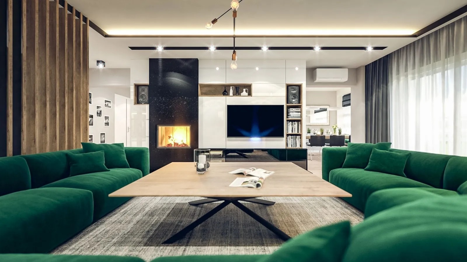 Nowoczesny salon z zieloną sofą modułową, kominkiem obudowanym czarnym marmurem, drewnianą ścianką działową i lampą sufitową z odsłoniętymi żarówkami.