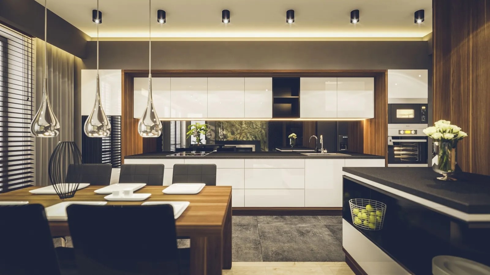Nowoczesna jadalnia z kuchnią w tle: drewniany stół z nakryciem, wiszące lampy o kroplowym kształcie, białe szafki kuchenne z czarnym blatem i drewnianymi akcentami, minimalistyczny wystrój.