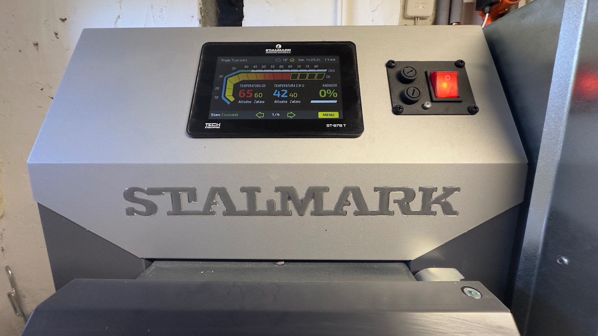 Szczegółowy widok panelu sterowania kotła grzewczego Stalmark ST-978 T, z wyświetlaczem pokazującym temperatury CO i CWU, oraz przyciskami i przełącznikiem.
