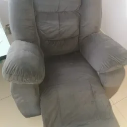 Szary, welurowy fotel rozkładany z widocznymi plamami, wymagający prania, sfotografowany w Święcku Wielkim.