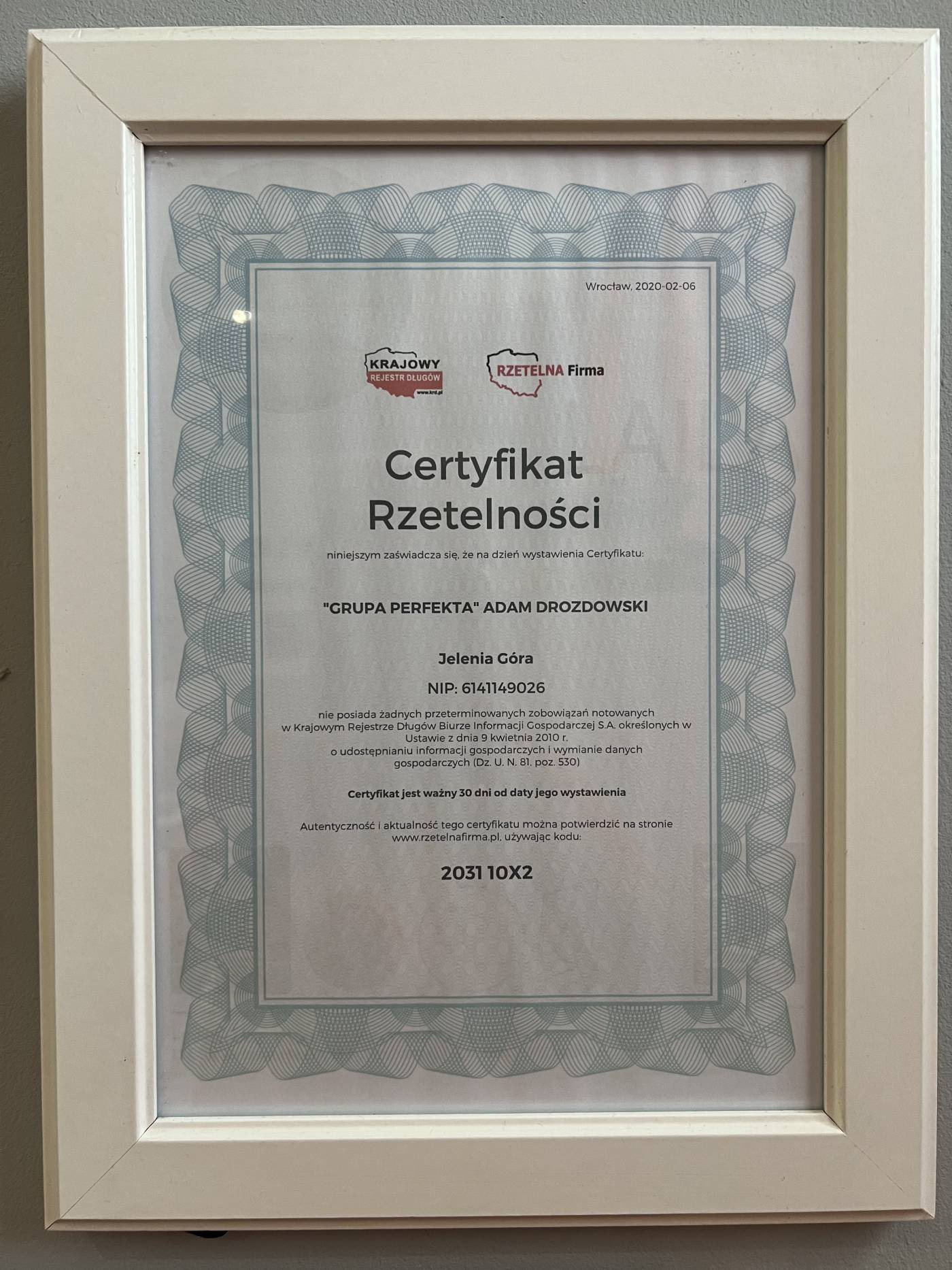 Oprawiony w ramkę certyfikat rzetelności firmy 'Grupa Perfekta' Adam Drozdowski, wystawiony we Wrocławiu 6 lutego 2020 roku, z widocznymi logotypami Krajowego Rejestru Długów i Rzetelna Firma.